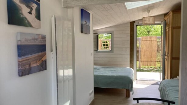 A bedroom with a bed, a window, and a view of the outdoors.