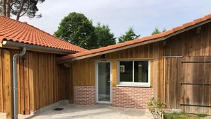 A small building with a tiled roof, a brick lower section, and a wooden exterior.