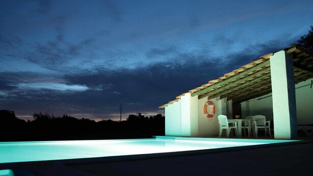 A modern outdoor pool area with a covered seating area and a lifebuoy on the wall. - 1-Bedroom apartment "Oliveira" – Pool view (2 + 2) (Mesquita)