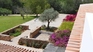 A garden with a stone pathway, a tree, and flowering plants. - 1-Bedroom apartment "Oliveira" – Pool view (2 + 2) (Mesquita)