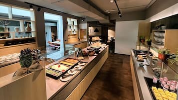 Zona de bufé con diversas opciones de comida y un área de asientos al fondo.
