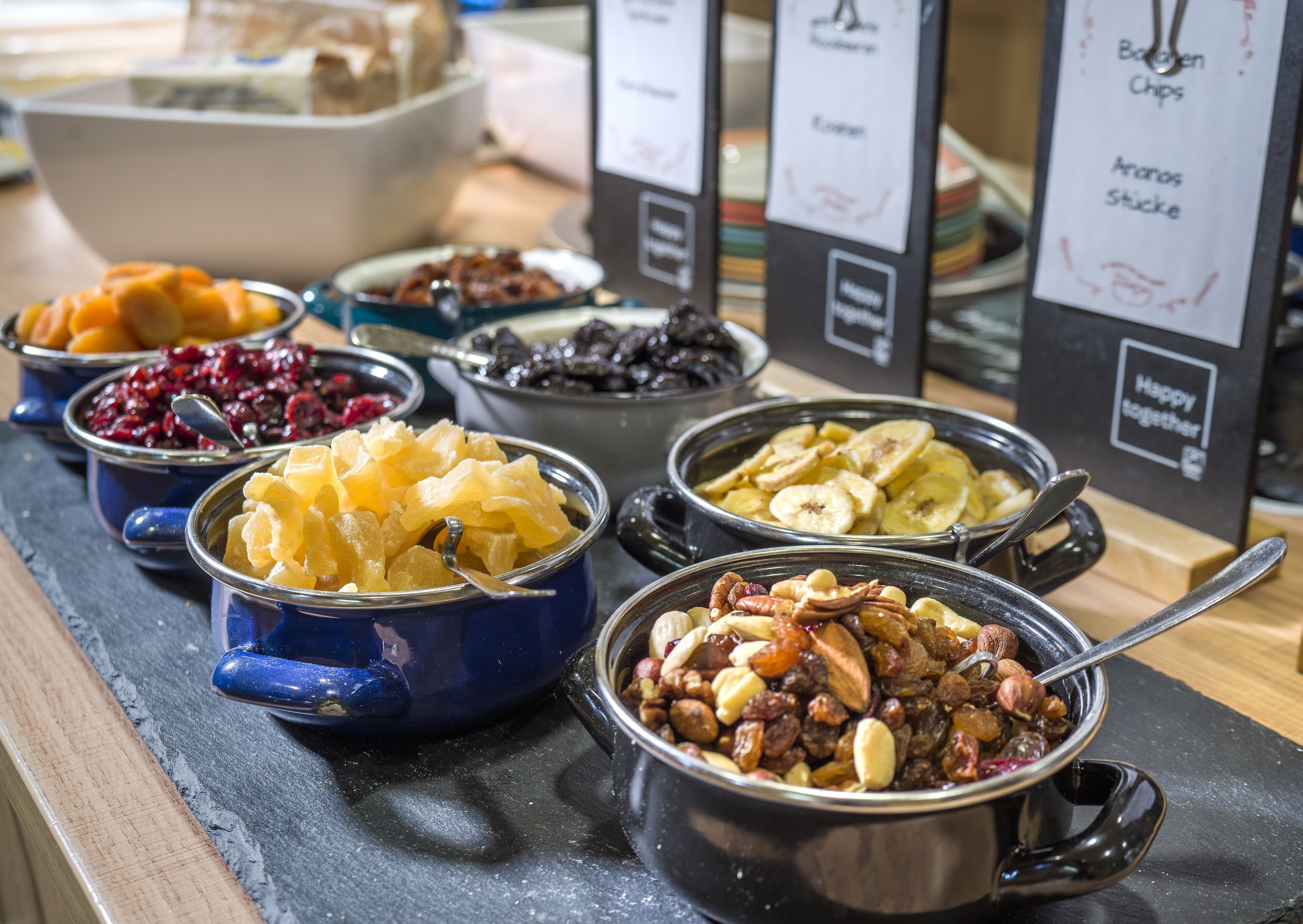 A buffet with various food options including fruits, nuts, and chips.