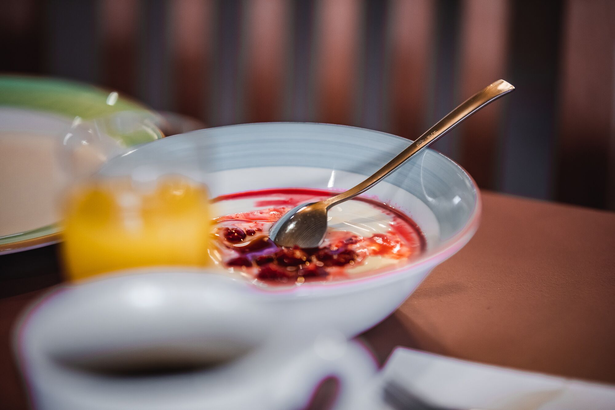 A bowl of yogurt with fruit and a spoon.