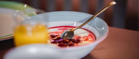 A bowl of yogurt with fruit and a spoon.