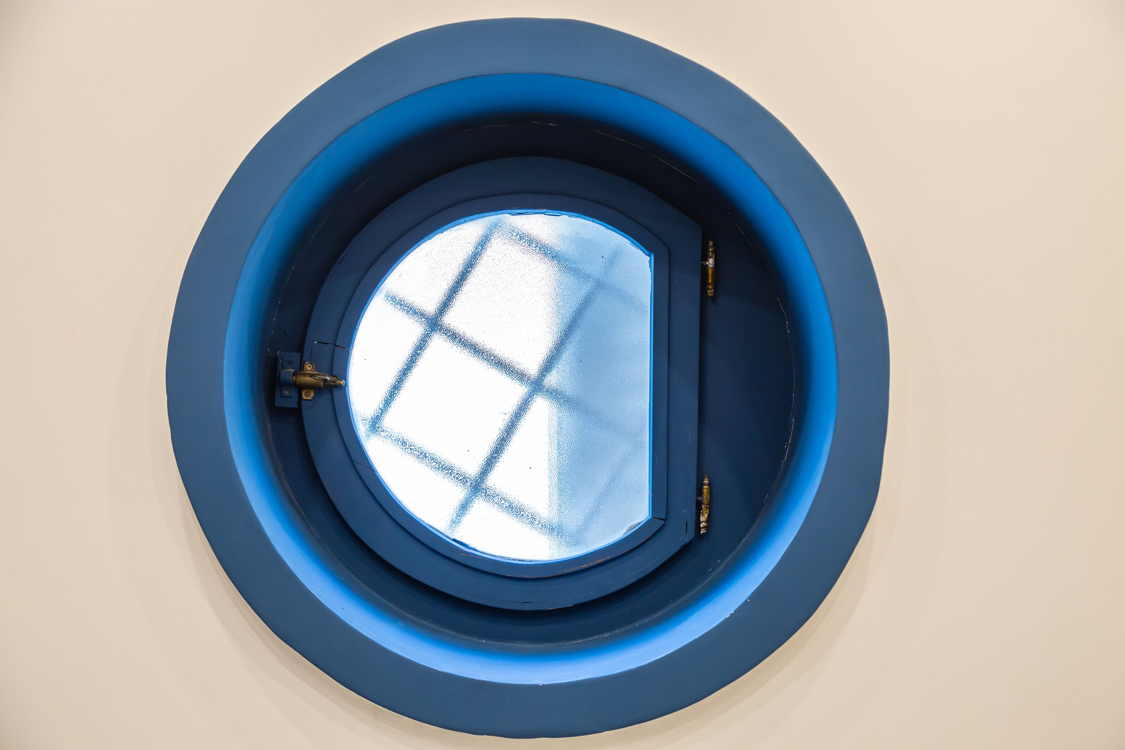 A circular skylight with a grid pattern, surrounded by a blue frame.