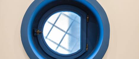 A circular skylight with a grid pattern, surrounded by a blue frame.