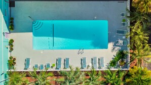 An aerial view of a pool area with lounge chairs and a pool. - A Place at the Beach | Easy Walk to the Sand + Community Pool! (Carolina Beach)