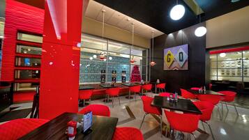 Un restaurante moderno con sillas y mesas rojas, un árbol de Navidad y un letrero que dice "GOGO".