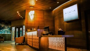Un área de recepción con un mostrador de madera, una araña y un letrero que dice 'AWANA SPA & WELLNESS'.