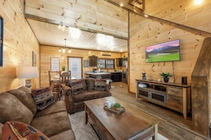 A wooden interior with a sofa, coffee table, and TV. - Private Indoor Pool*Hot Tub*Fireplace*Easy Access (Pigeon Forge)