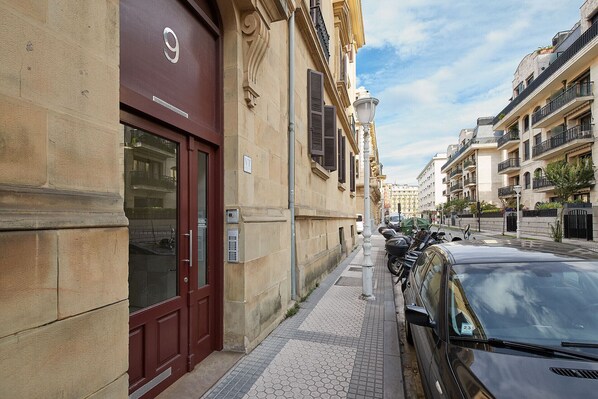 A street view with a building featuring a large number '9' sign, a red door, and a parked car. - Eiffel | The Rentals Collection (San Sebastián/Donostia)