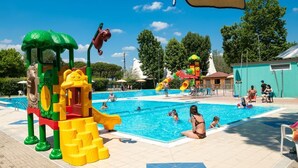 Ein Schwimmbeckenbereich mit Spielgeräten und einer Rutsche.