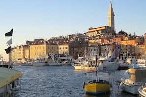 Un port avec des bateaux, une église imposante et des bâtiments aux couleurs vives.
