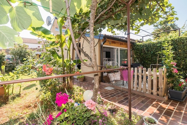 A garden with a pergola, potted plants, and a wooden fence.