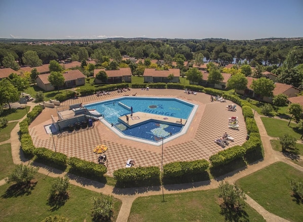 Relax by the pool surrounded by lush greenery and lounge under shaded umbrellas.