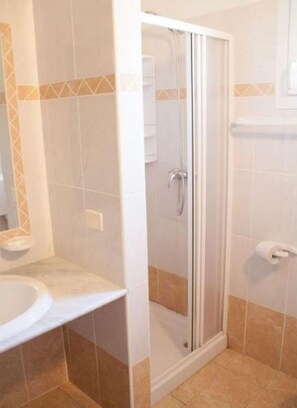 Enjoy a refreshing shower in this bathroom with a glass-enclosed shower area, white sink, and matching countertop.