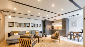 A modern living room with a sofa, chairs, a coffee table, and a dining area with a table and chairs. - Urban Flat 170 - Sublime Flat in Center of Paris (París)