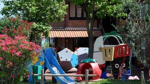 A playground with various play structures including a slide, climbing frames, and a ball pit.