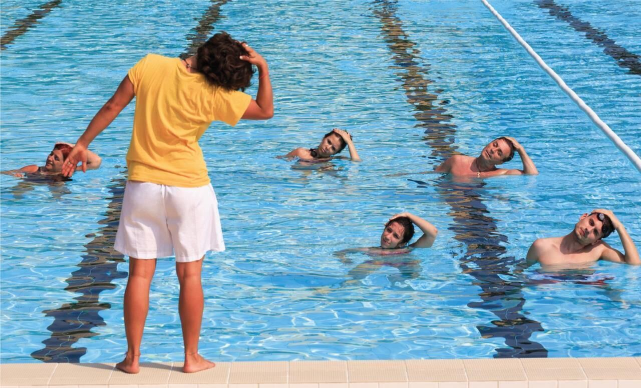 A swimming pool with multiple lanes and swimmers.