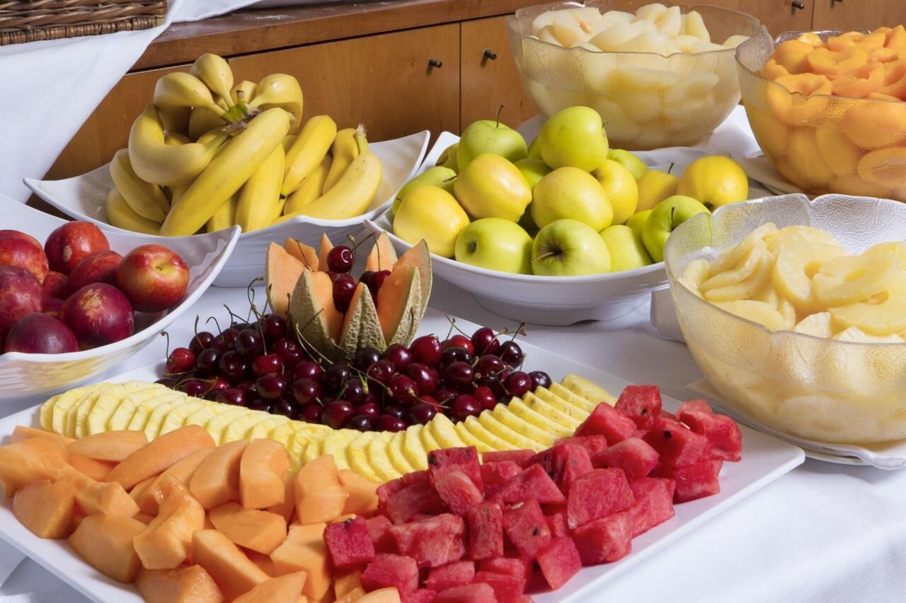 A variety of fruits including bananas, apples, cherries, and watermelon on a table.