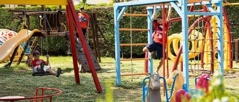 A playground with various play structures including slides, swings, and climbing frames.