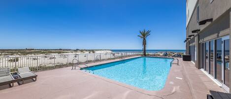 A rooftop pool with a clear view of the beach and ocean.