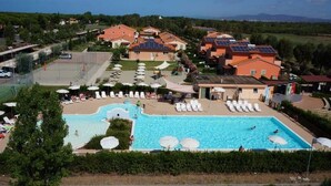 Un complexe hôtelier doté d’une grande piscine, de chaises longues et de panneaux solaires sur les toits.