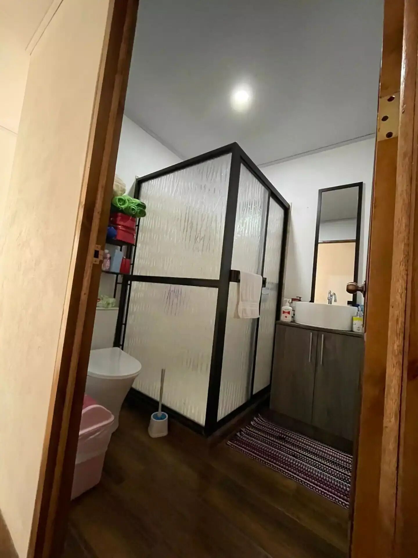 Un baño pequeño con inodoro, lavabo y armarios de almacenamiento.