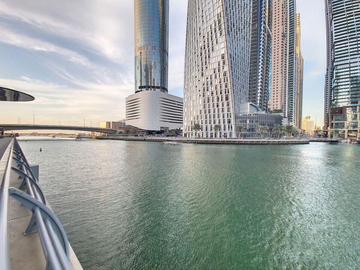 Une vue sur le front de mer, avec des immeubles modernes, un pont et une rivière paisible.