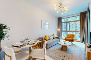Relax in this stylish room with a dining area and living space, featuring a round table for four and a comfortable sofa.