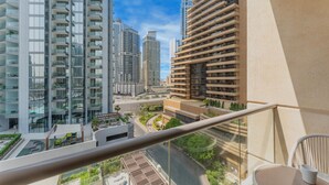 A high-rise building with multiple balconies, a clear sky, and a view of a cityscape.