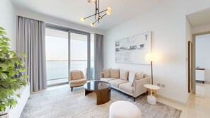 A modern living room with a sofa, armchairs, a coffee table, and a floor lamp.