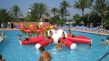 Une piscine où des gens nagent, jouent et se détendent.