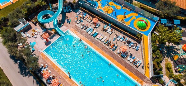 Ovenfra set et vandland med en stor pool, en vandrutsjebane og liggestole.