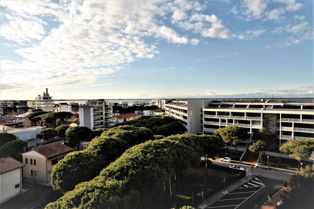 Un parking à étages offrant une vue dégagée sur le paysage urbain environnant, notamment sur les bâtiments et les arbres.