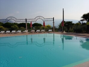 Una piscina con lettini da sole e un arco decorativo in metallo.