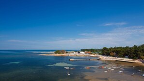 Une zone côtière dotée d’un port de plaisance, de bateaux et d’une plage.