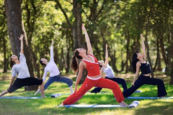 Un grupo de personas practicando yoga en un parque.