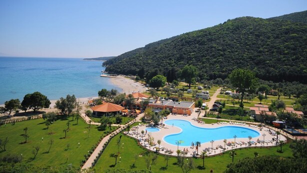 Un complexe hôtelier doté d’une grande piscine, d’un accès à la plage et d’une végétation luxuriante.