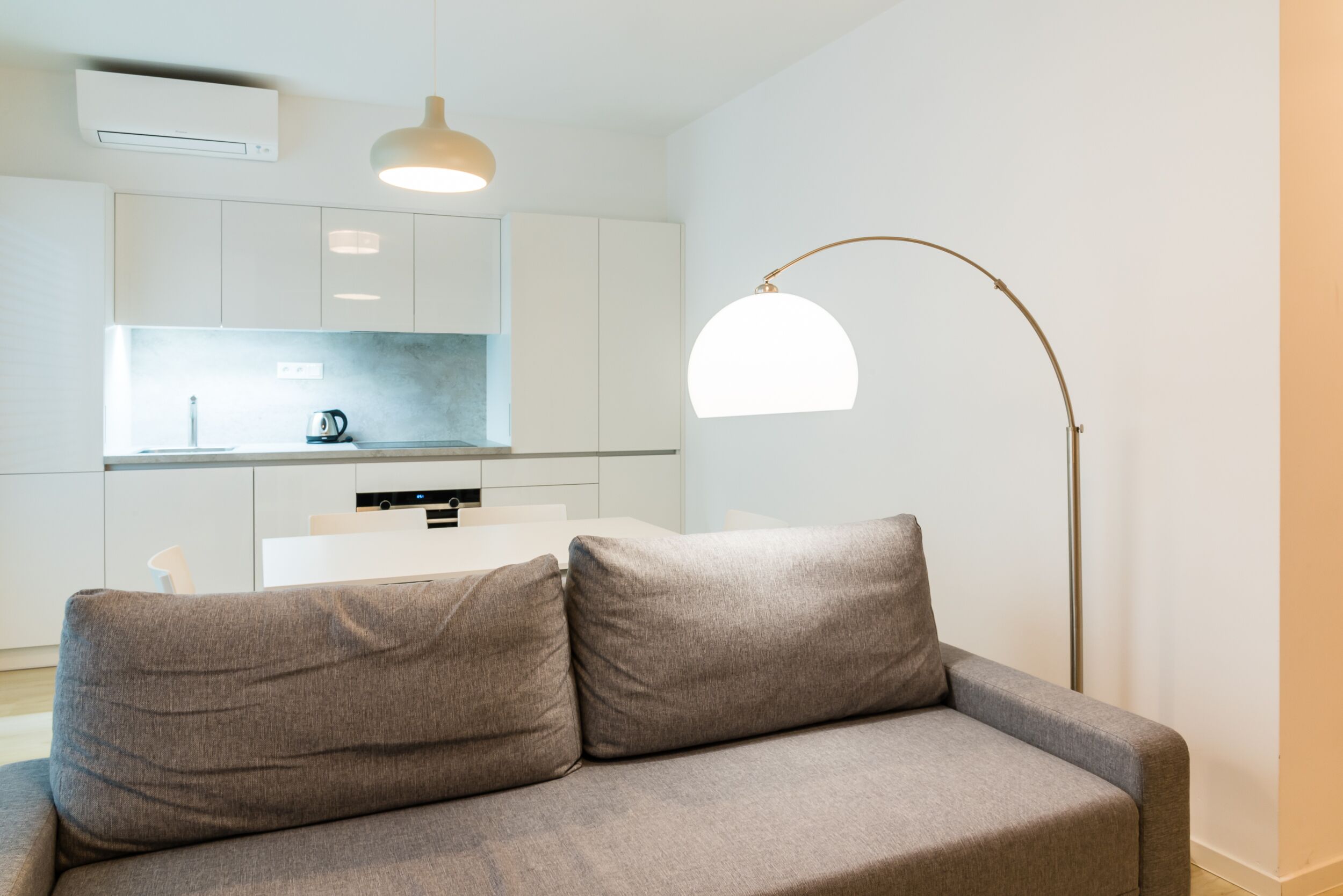 A modern living room with a grey sofa, a coffee table, and a floor lamp.