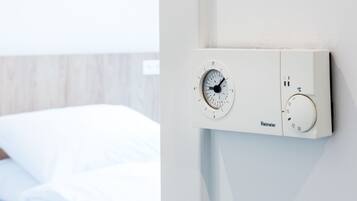 Un thermostat doté d’un panneau de commande et d’un indicateur de température, affichant les réglages de température de la pièce.
