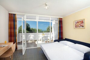Enjoy a comfortable stay in this stylish room featuring a large bed, desk, and balcony with outdoor seating.