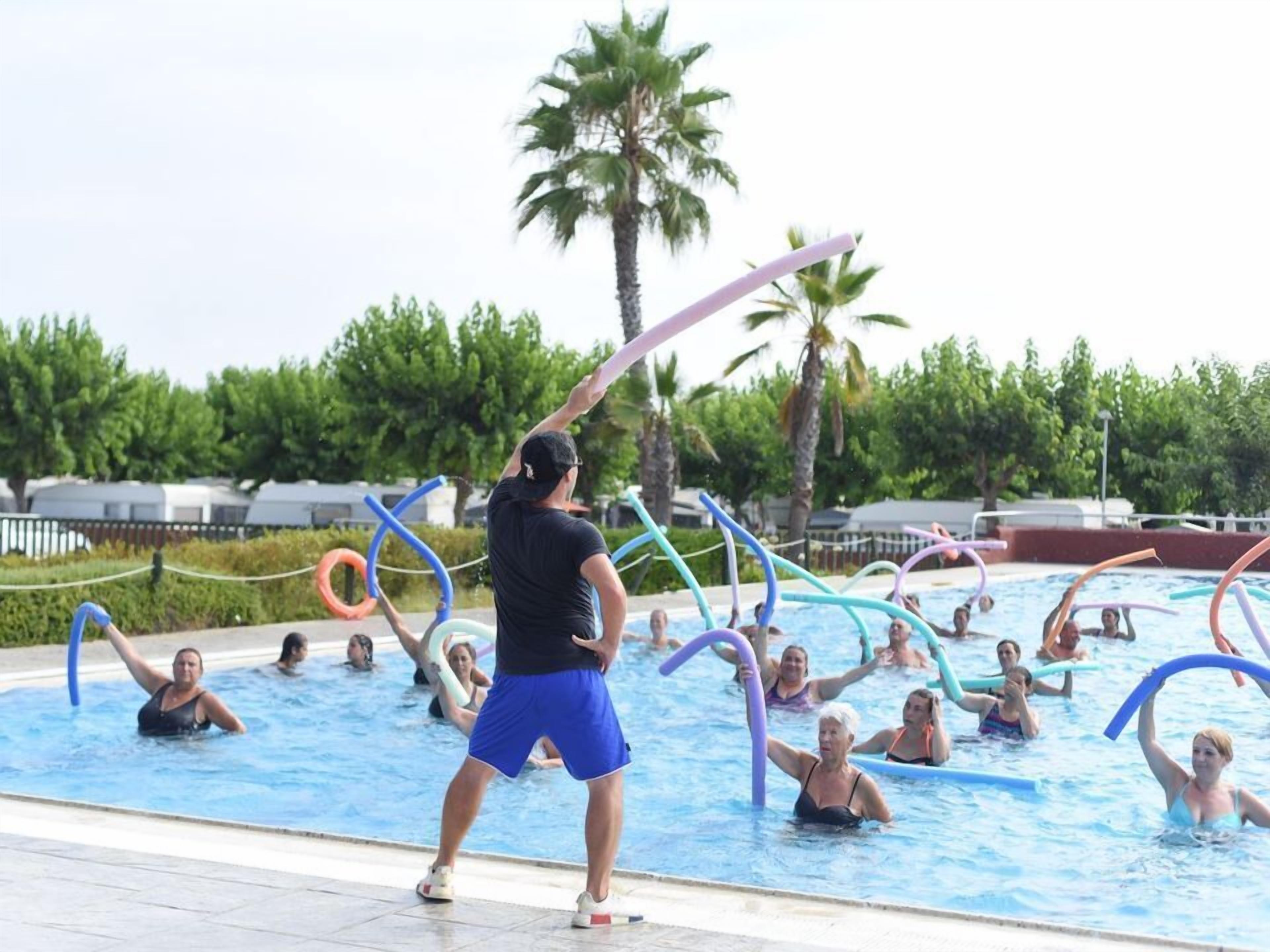 Una piscina con gente haciendo ejercicio con bandas de resistencia.
