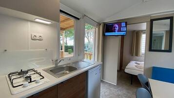 Een koelkast, een kinderstoel, kookgerei, borden en bestek