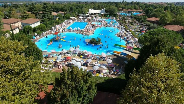 Un'ampia piscina all'aperto circondata da sdraio e ombrelloni, con vista sul paesaggio circostante.
