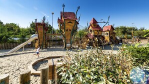 Un parque infantil con estructuras de madera y un tobogán.
