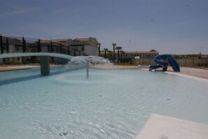 Une piscine avec une fontaine et une sculpture bleue.