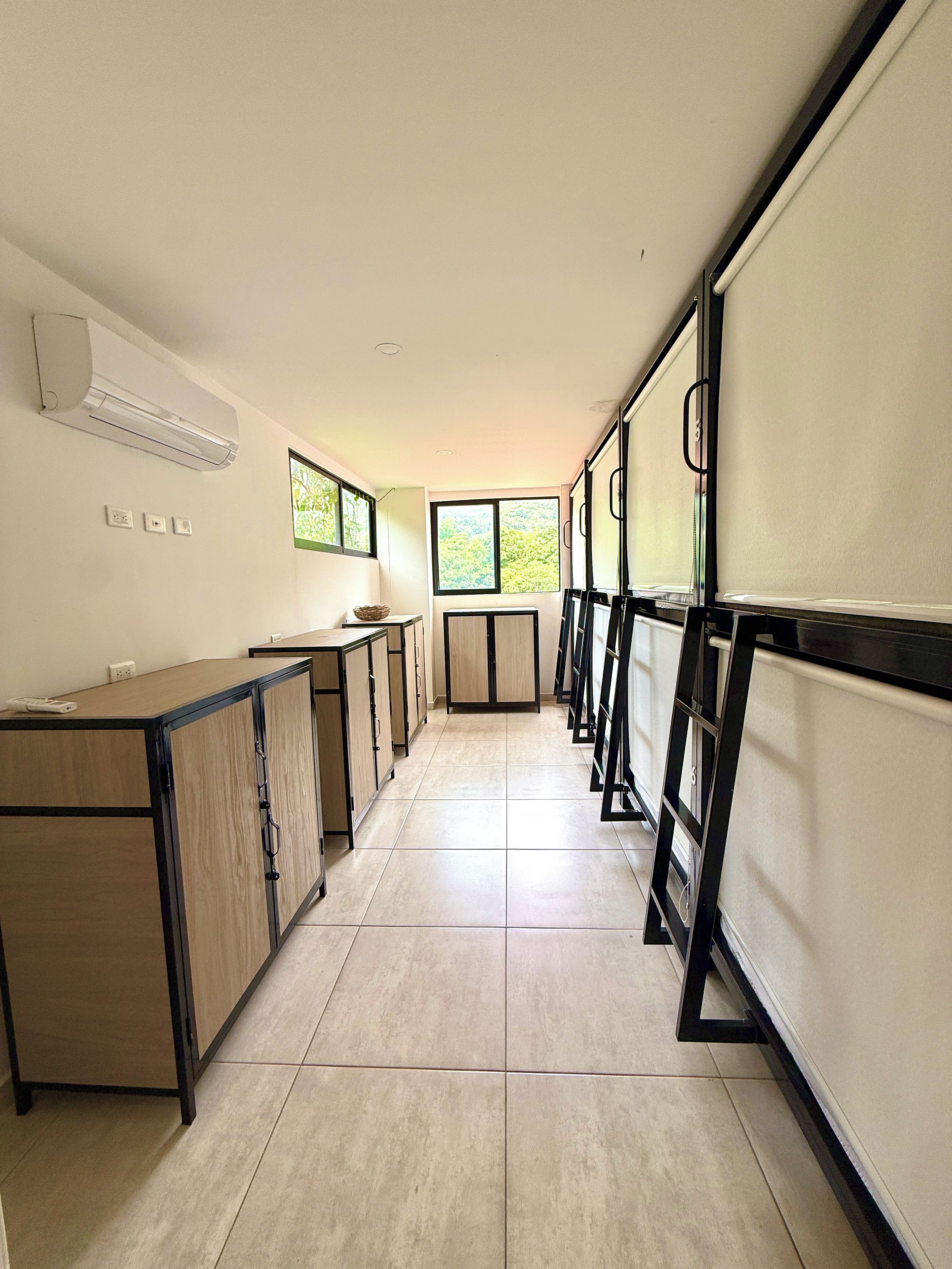 A corridor with a kitchenette area, cabinets, and a window providing natural light.
