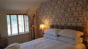 A neatly made bed with white linens, two bedside lamps, a wooden hanger, and a window with blinds. - The Star Inn (Driffield)
