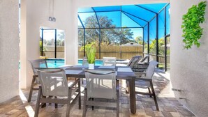A patio with a pool, outdoor seating, and a blue canopy. - Venice 3 bedroom contemporary home with pool/spa and close to beautiful beaches (Venice)